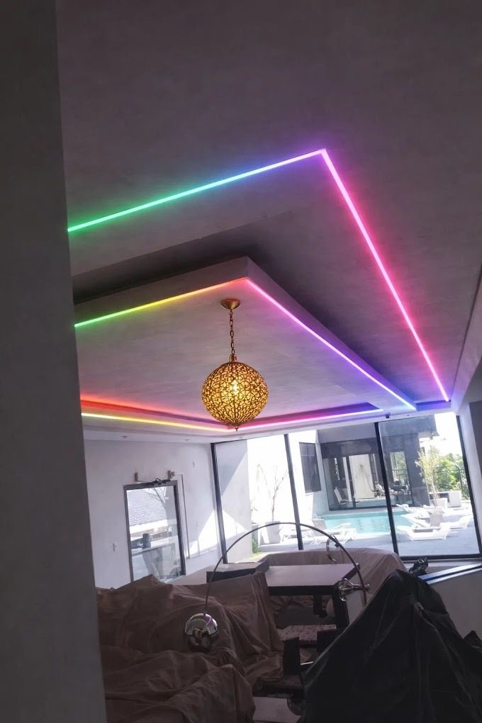 A folded ceiling detail with the strip following every edge, and a pendant dropped through the centre.